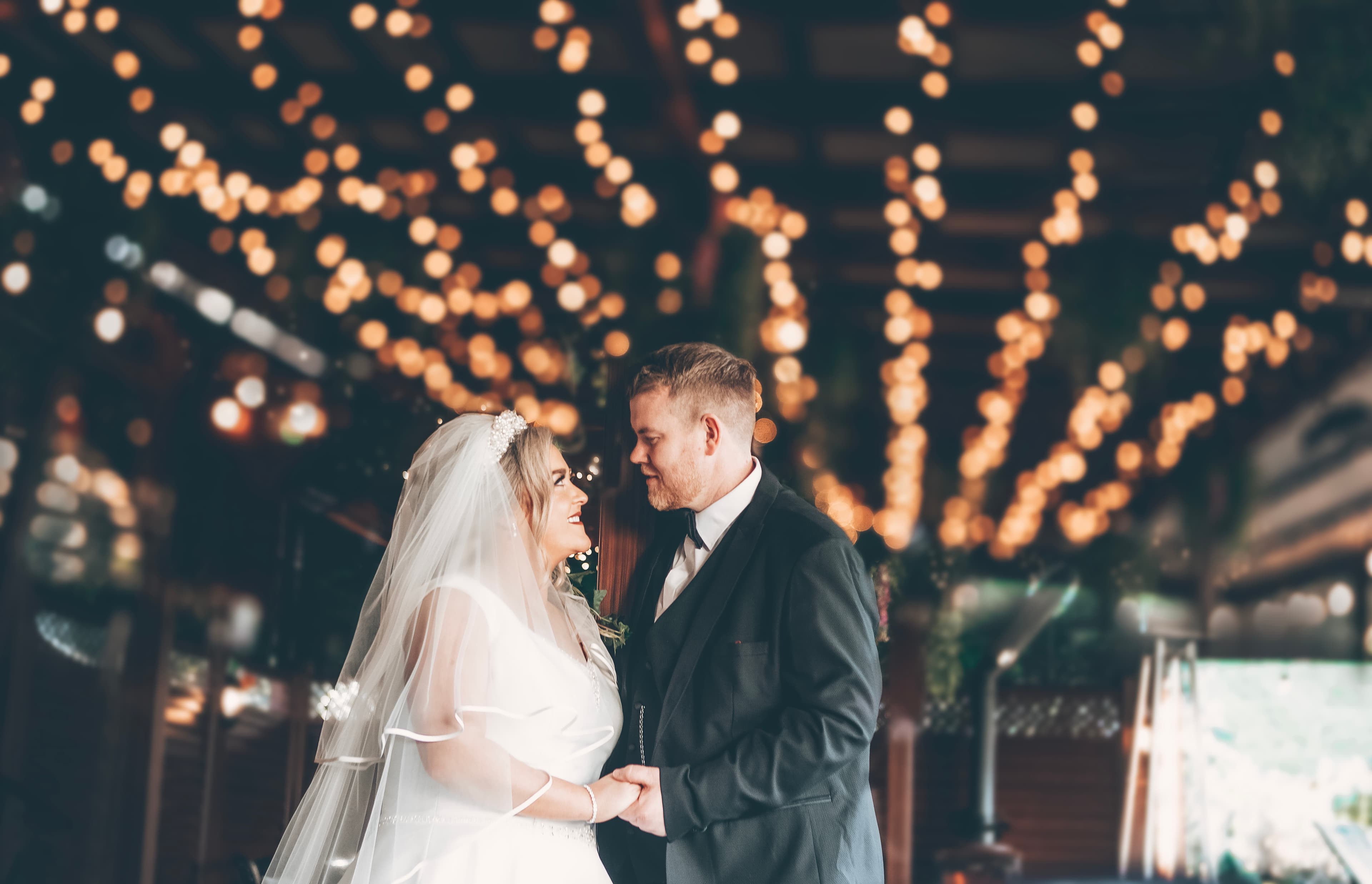 Couple under fairy lights canopy